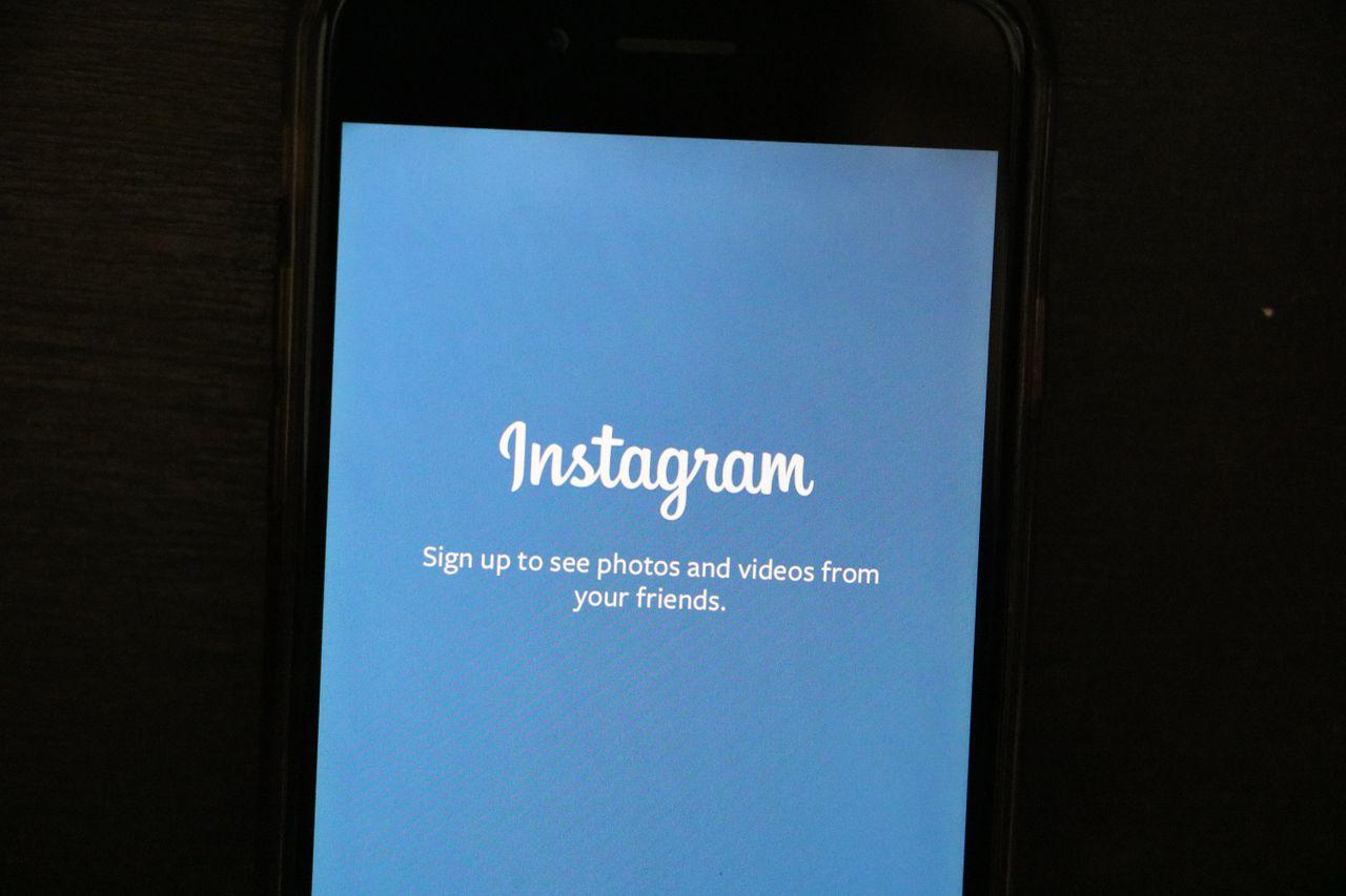 Vue rapprochée d’un smartphone affichant l’écran d’accueil de l’application Instagram, invitant les utilisateurs à s’inscrire.